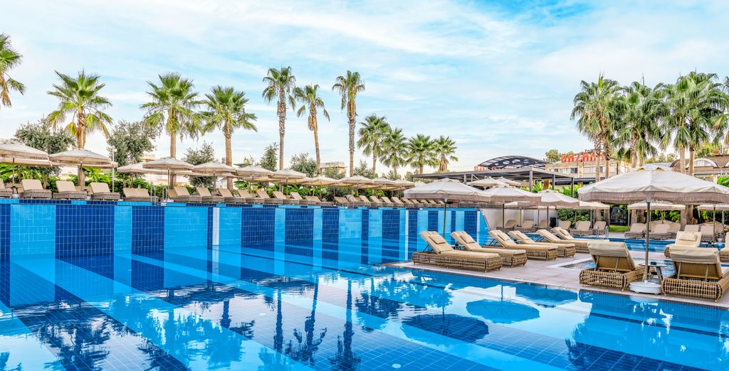 Belek Beach Resort 5 étoiles, piscine et transats sous les palmiers à Belek